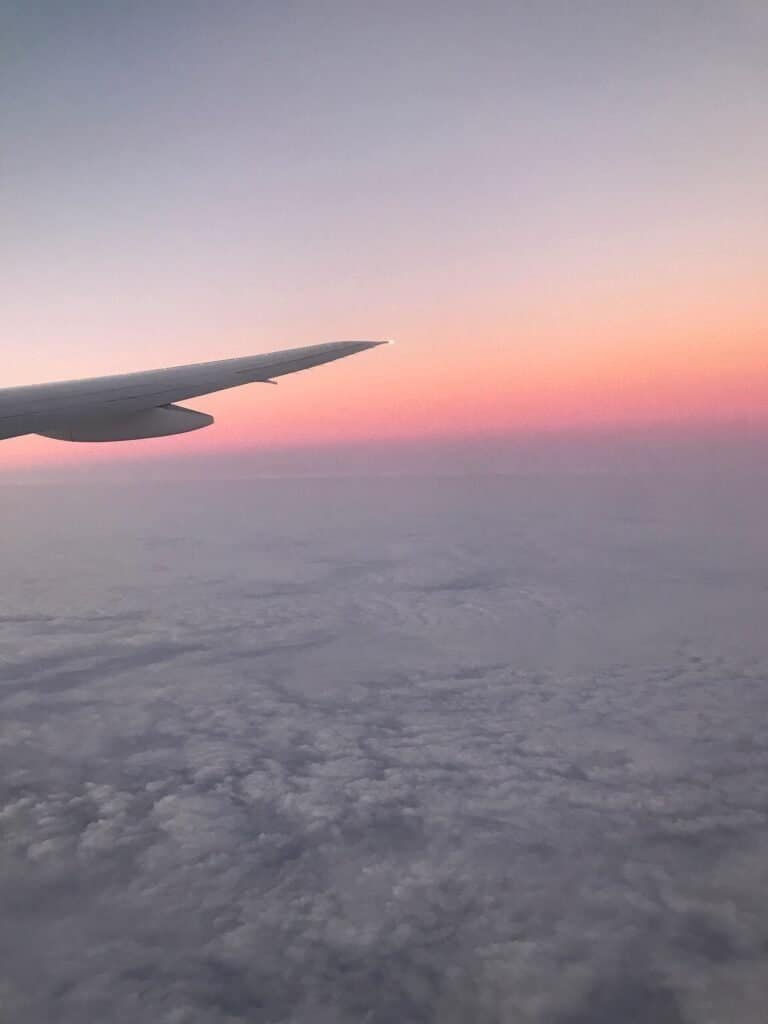 Avião comercial voando contra o céu azul com nuvens