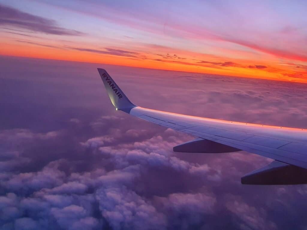 Vista pela janela do avião mostrando a asa durante o nascer do sol