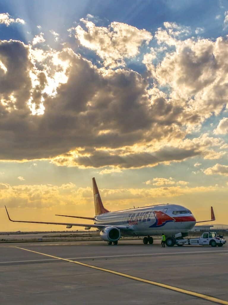 Trator de reboque realizando a operacao de pushback em uma aeronave comercial