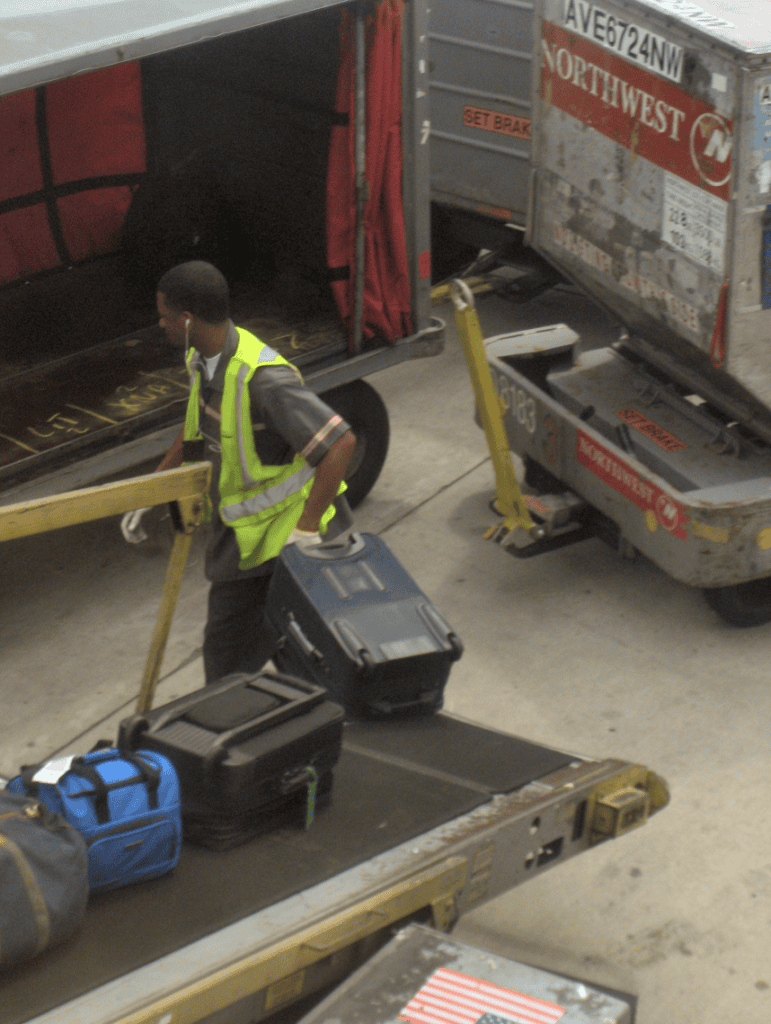 Agente de rampa trabalhando no carregamento de bagagem em um aeroporto