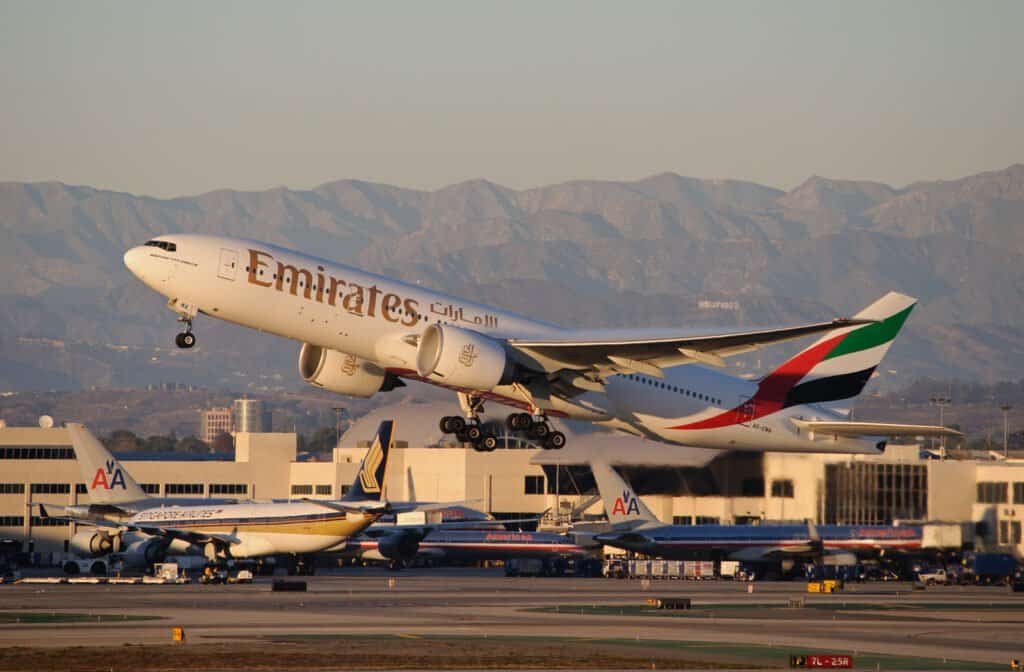 Boeing 777-200LR decolando, asa com condensação visível