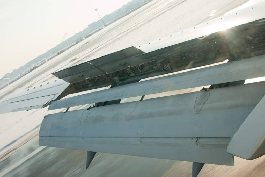 Boeing 737 pousando com flaps e spoilers estendidos, ilustrando frenagem em pista