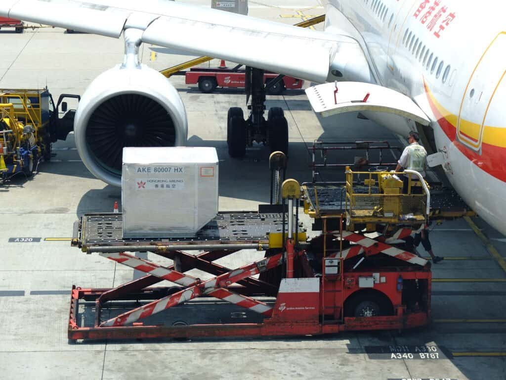 Carregador de contêineres ULD em operação ao lado de uma aeronave de carga
