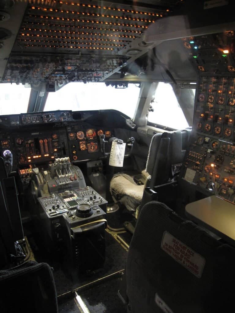 Cockpit de um Boeing 747 clássico mostrando os instrumentos analógicos e o painel de navegação inercial