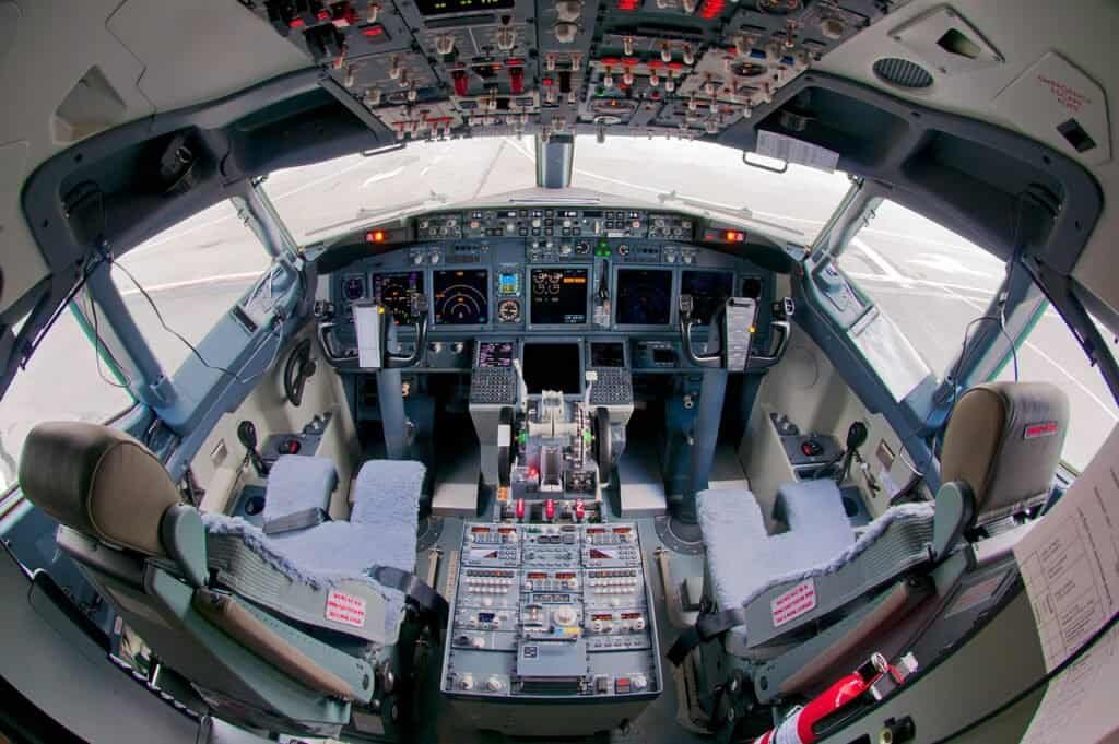 Cockpit de um Boeing 737-800 mostrando o painel de instrumentos e o CDU entre os pilotos