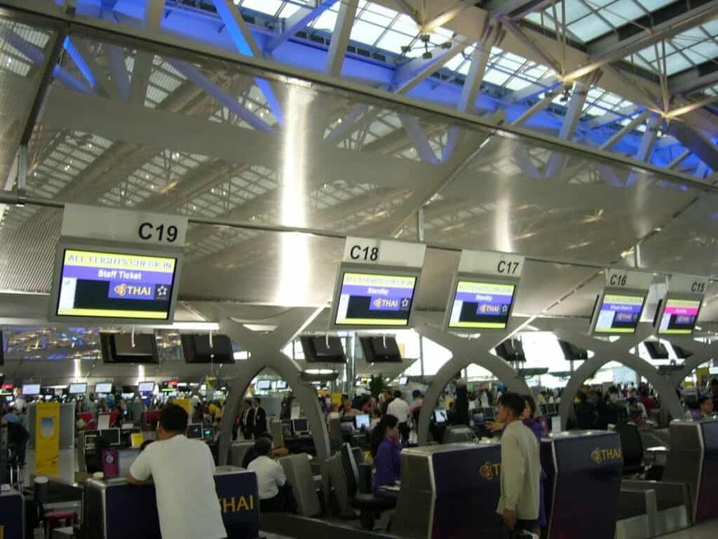Fileira de balcões de check-in da Thai Airways em terminal de aeroporto