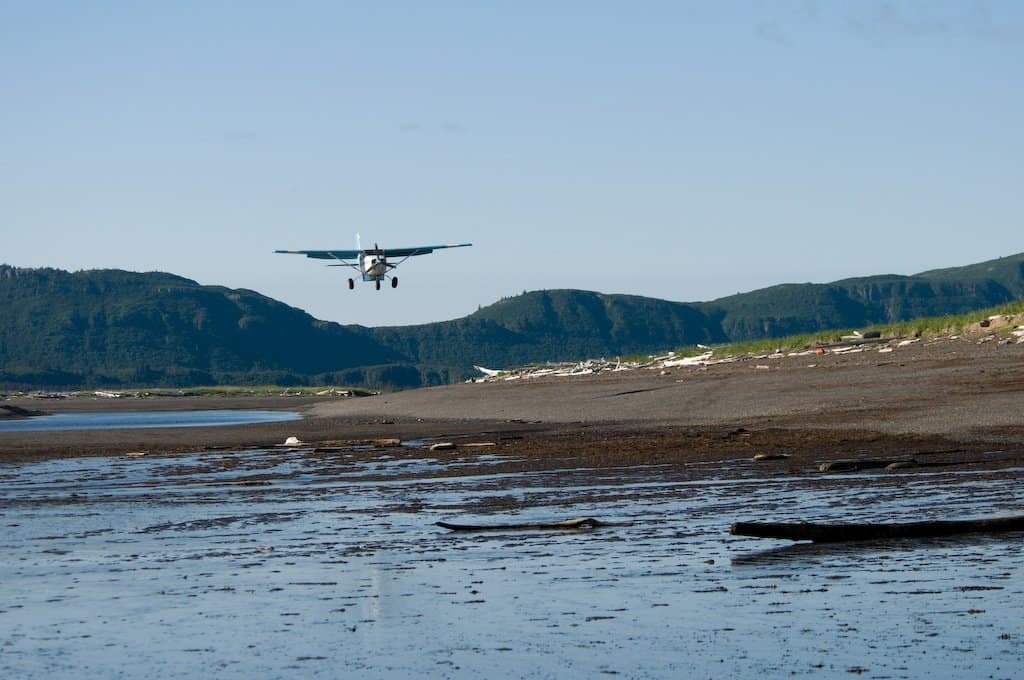 Avião leve pousando em pista curta na praia de Hallo Bay, Alasca — ilustração do conceito de pouso e decolagem ultracurtos