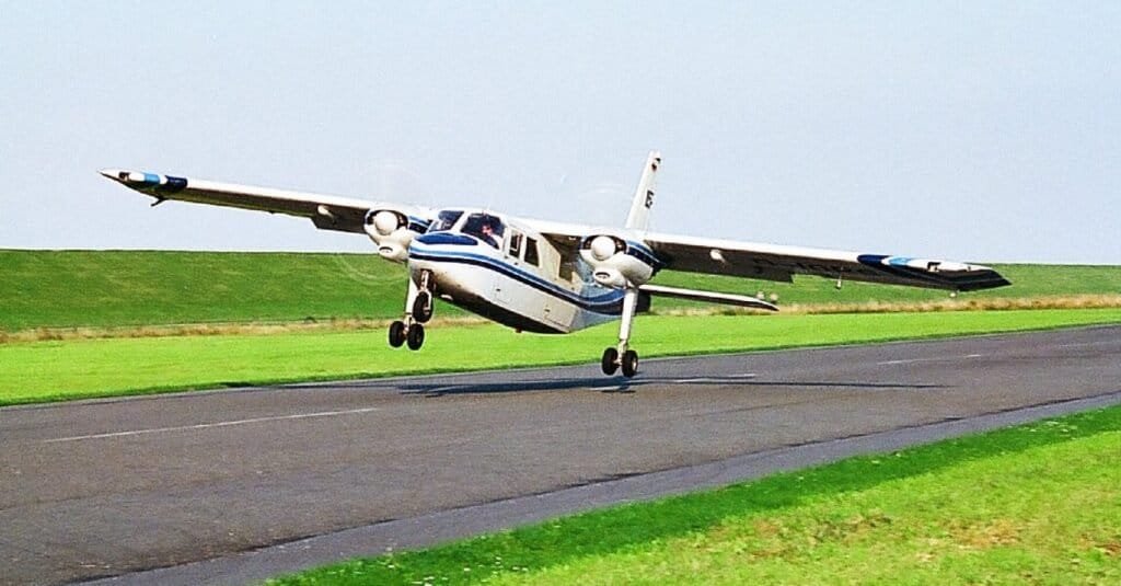 Avião Britten-Norman Islander pousando com a asa inclinada contra o vento, técnica usada em pousos com vento de través
