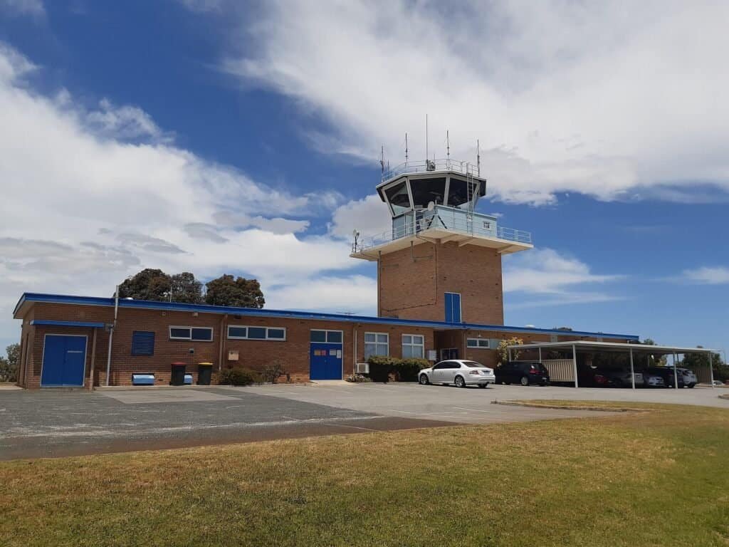 Torre de controle de tráfego aéreo vista do solo, com antenas e cabine de vidro no topo